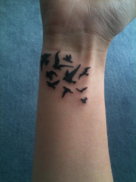 Tattoo på håndleddet av en fugl